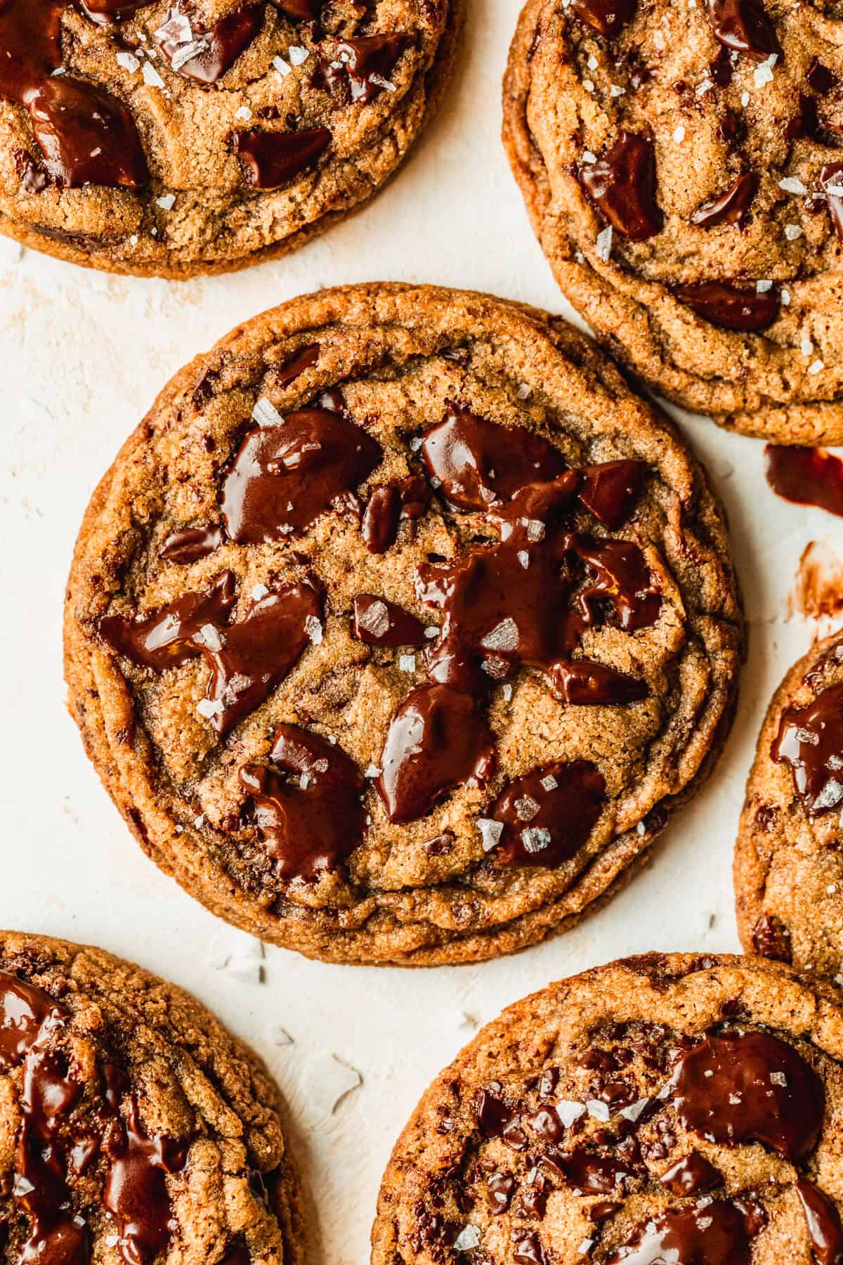 Rows of small-batch chocolate chip cookies on a beige counter.