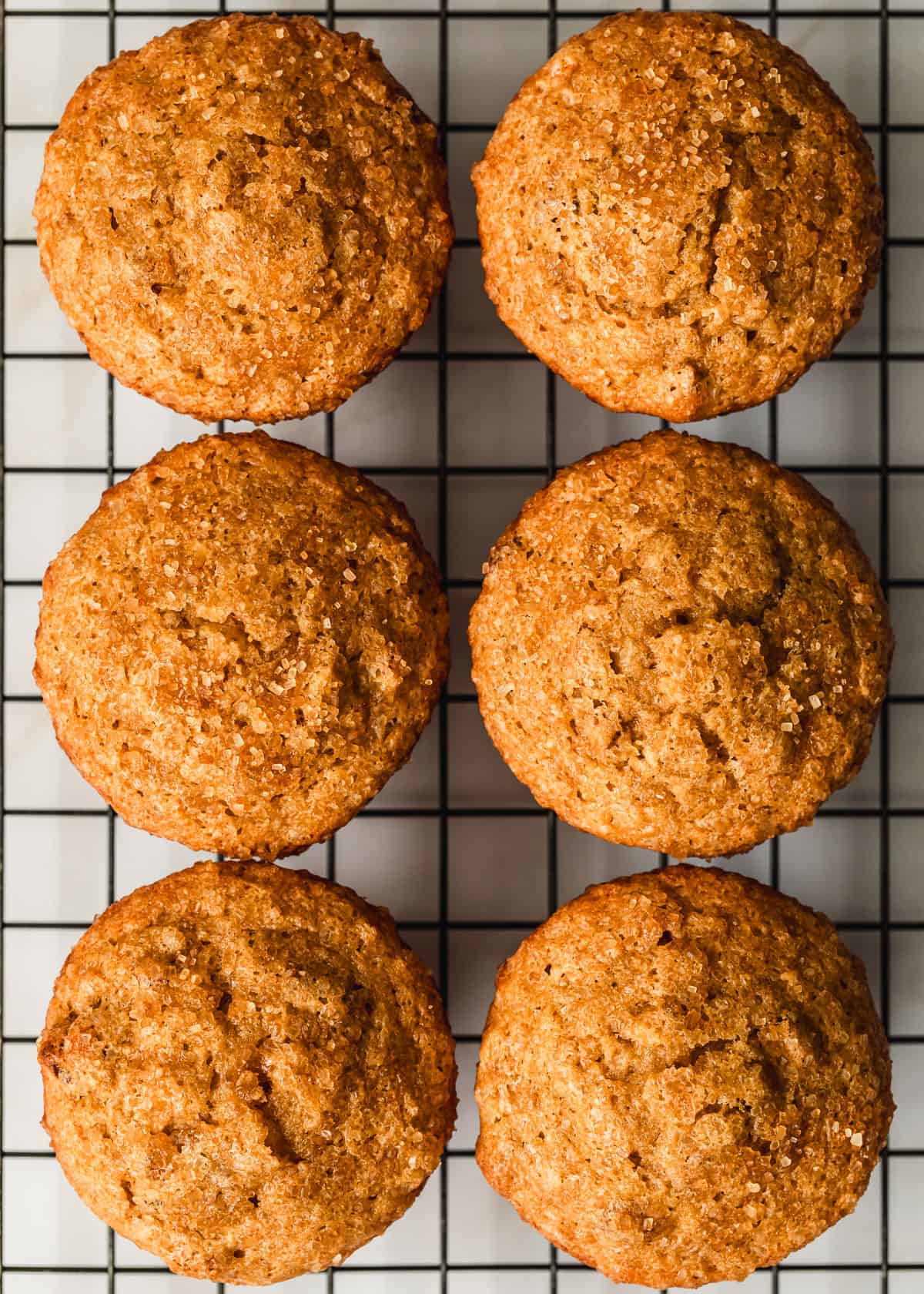Rows of small batch banana muffins on a wire rack.