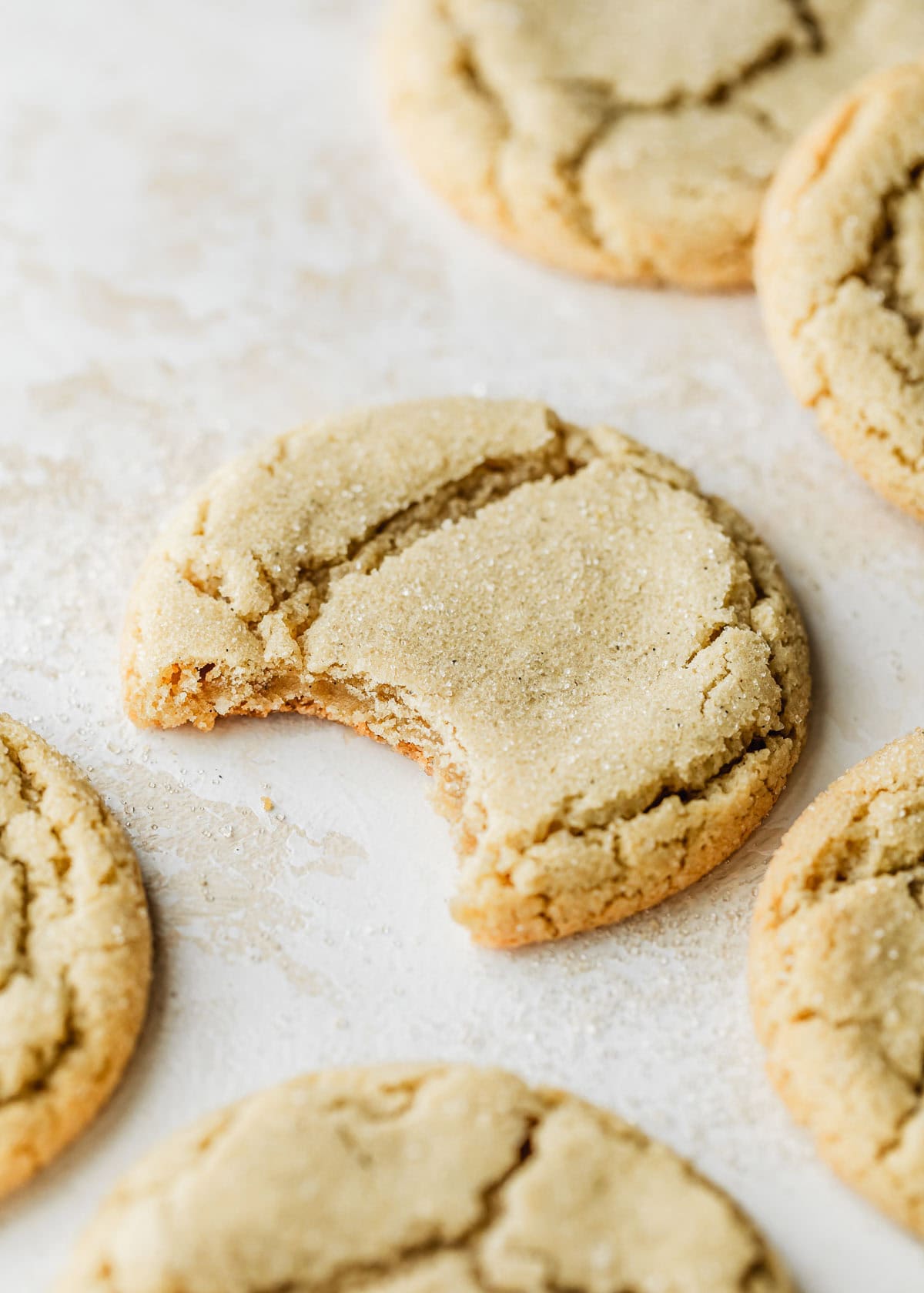 Rows of small batch sugar cookies on a beige and white counter.