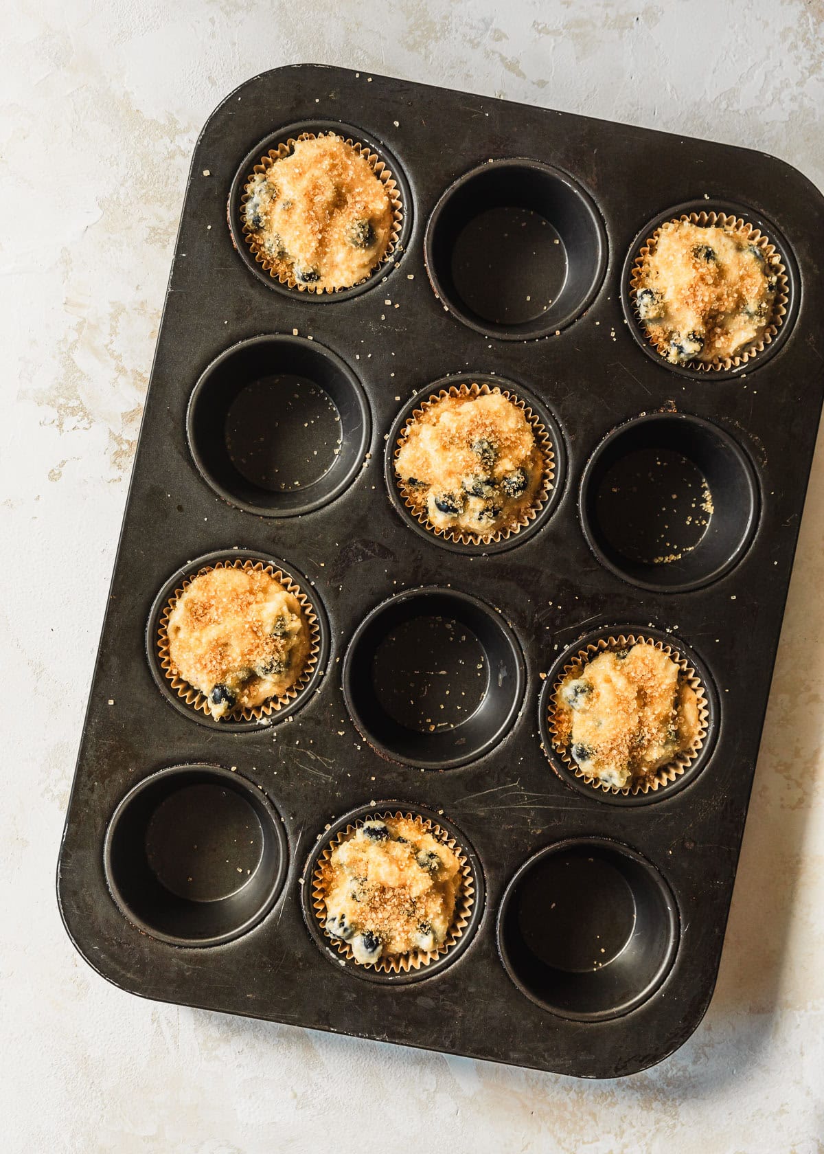 Raw small batch blueberry muffins in a black pan.