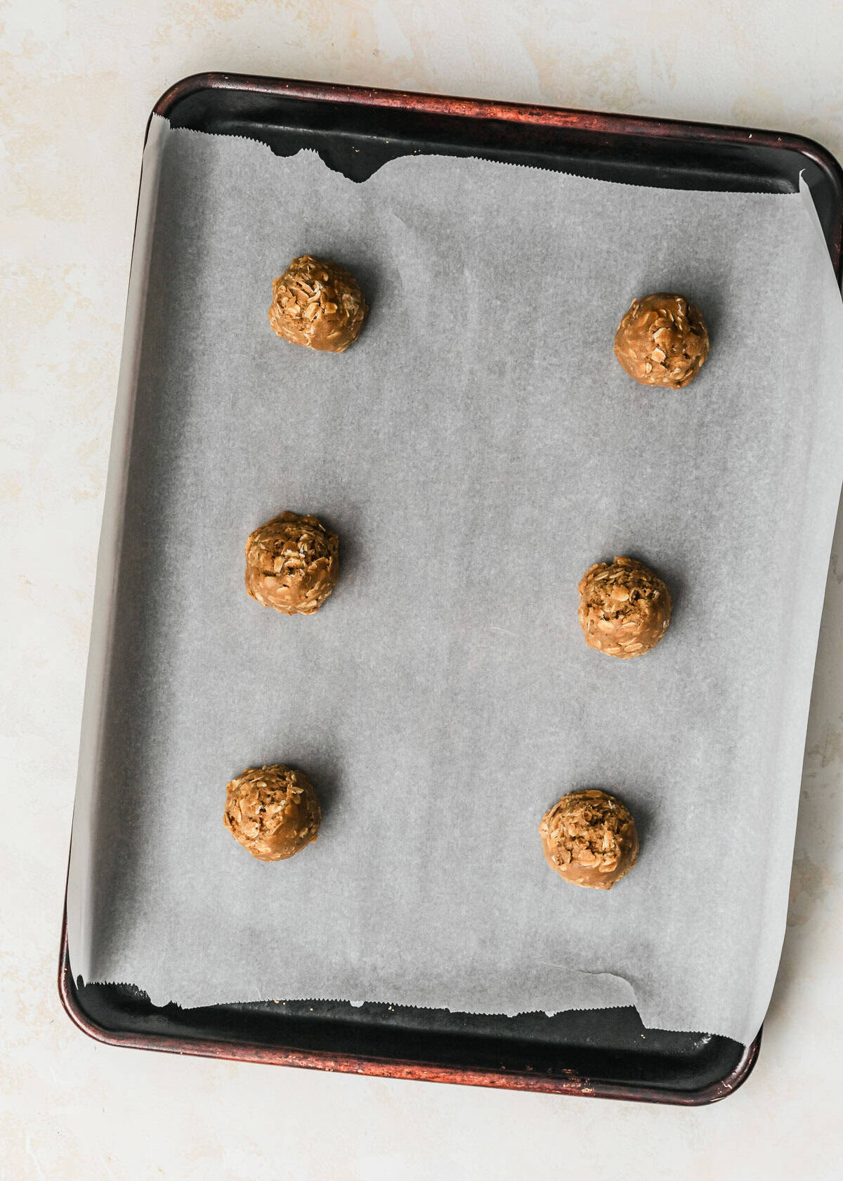 Raw small batch oatmeal cookies on a sheet pan.