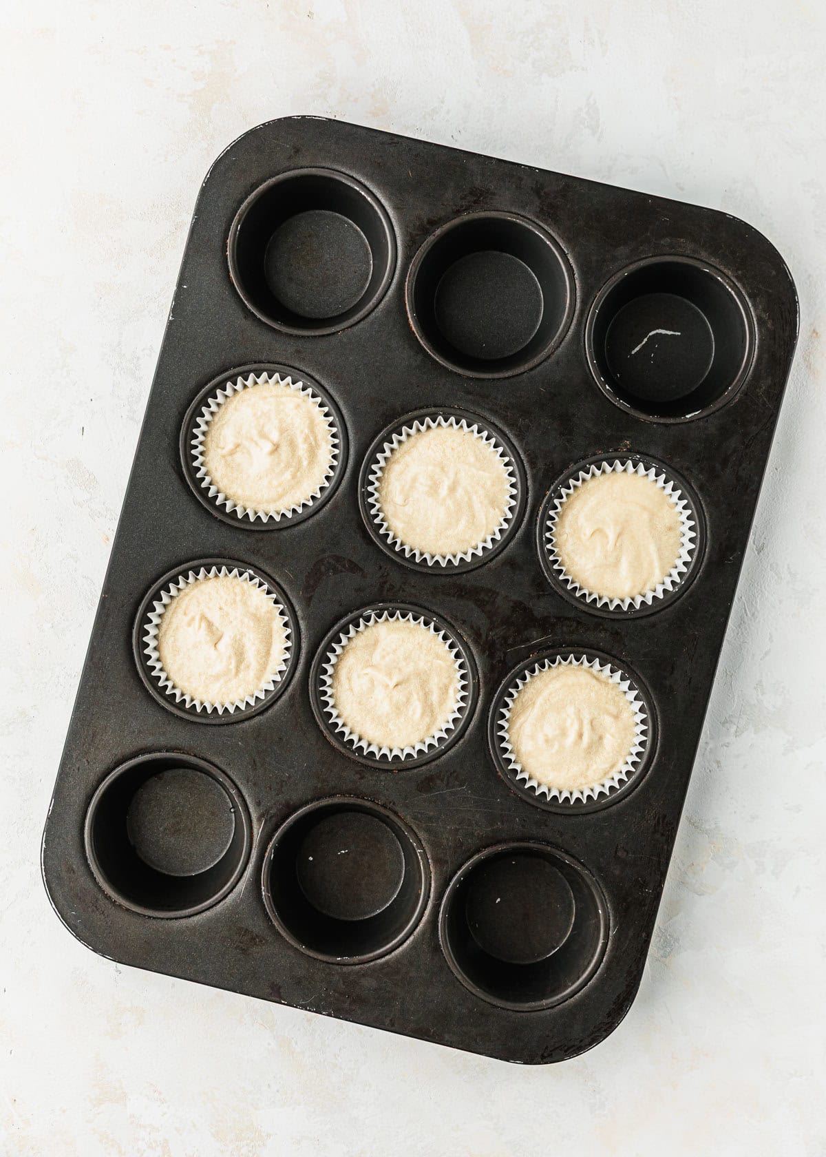 A pan with 6 raw cupcakes for small batch Easter egg cupcakes.