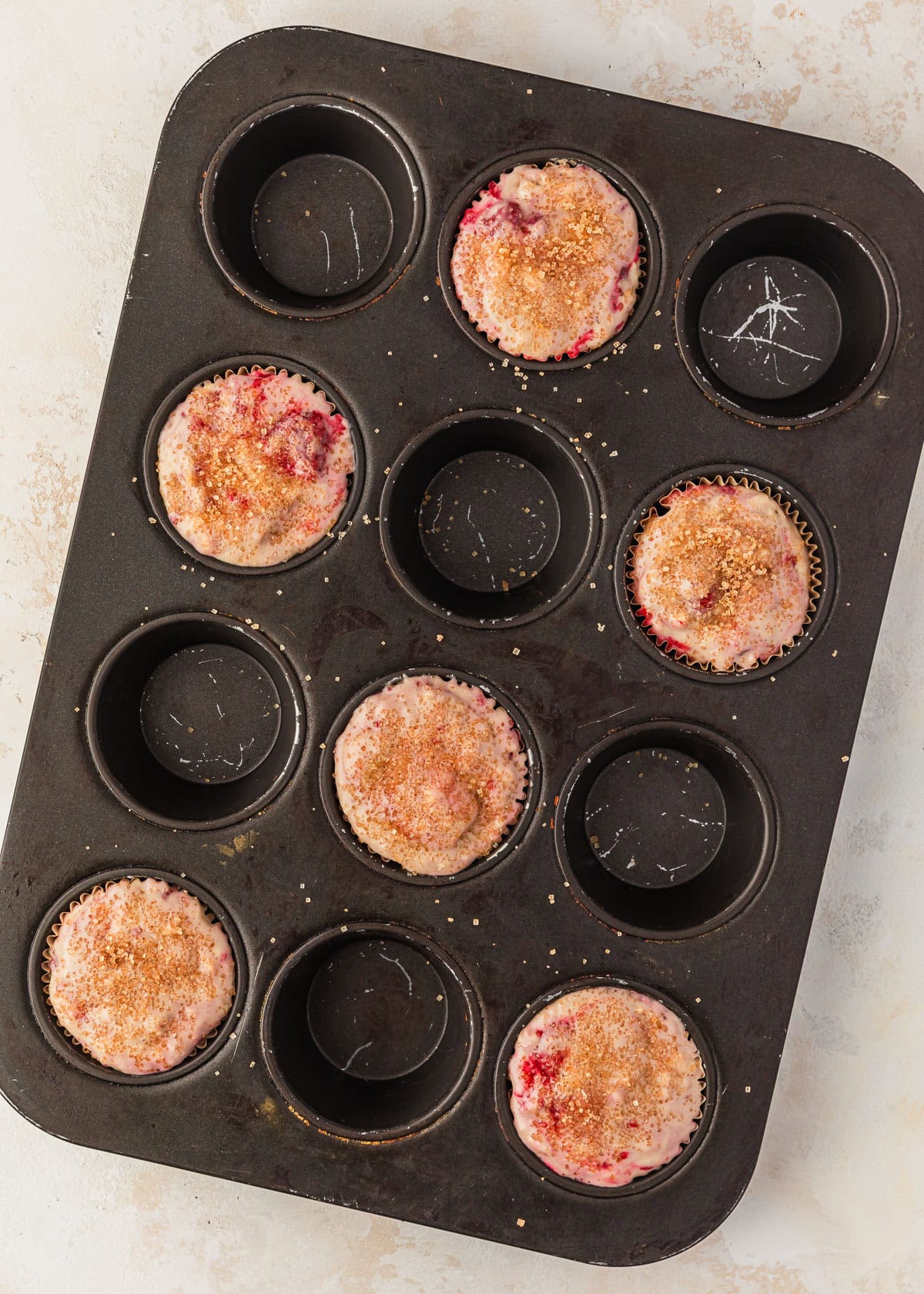 A pan of raw small batch raspberry banana muffins.