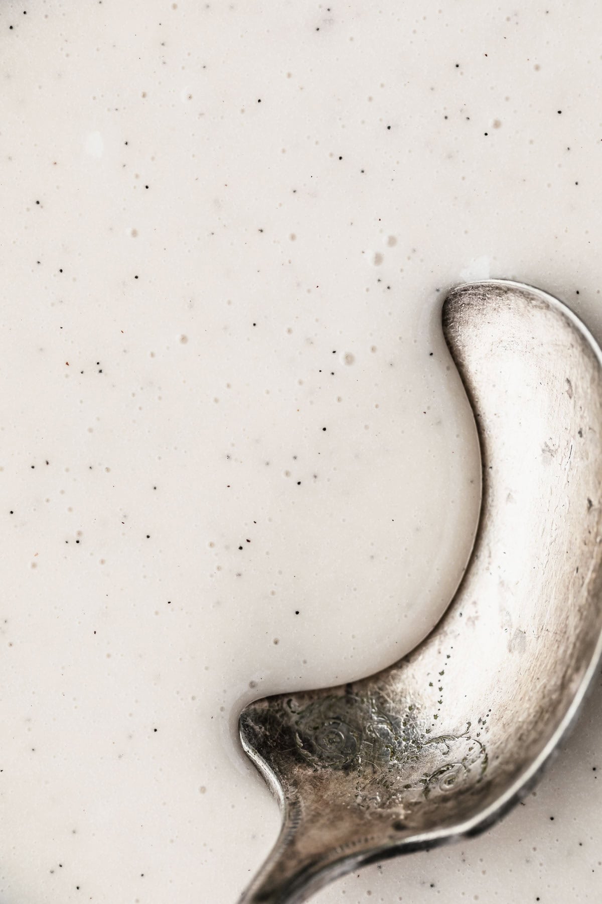 A spoon scooping small batch vanilla glaze.