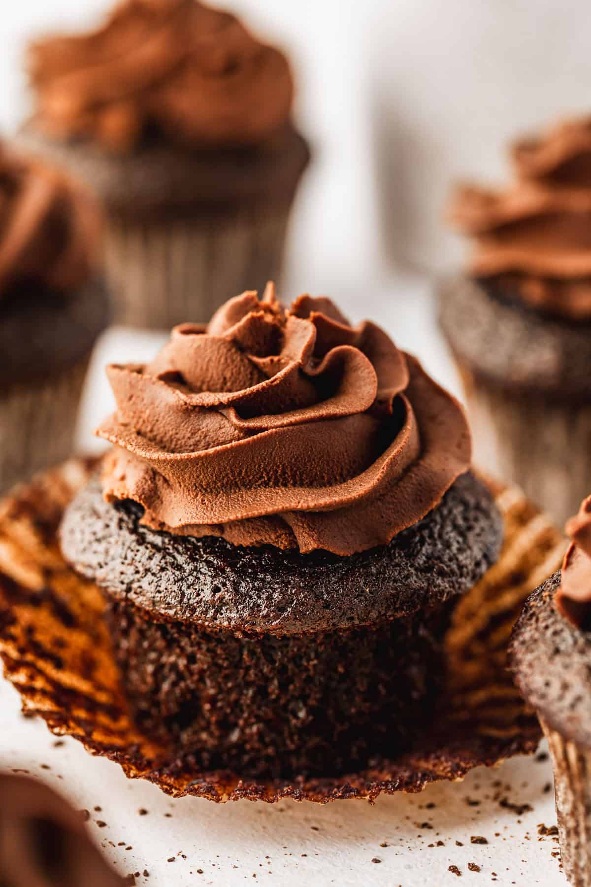 Rows of small batch chocolate cupcakes on a white counter.