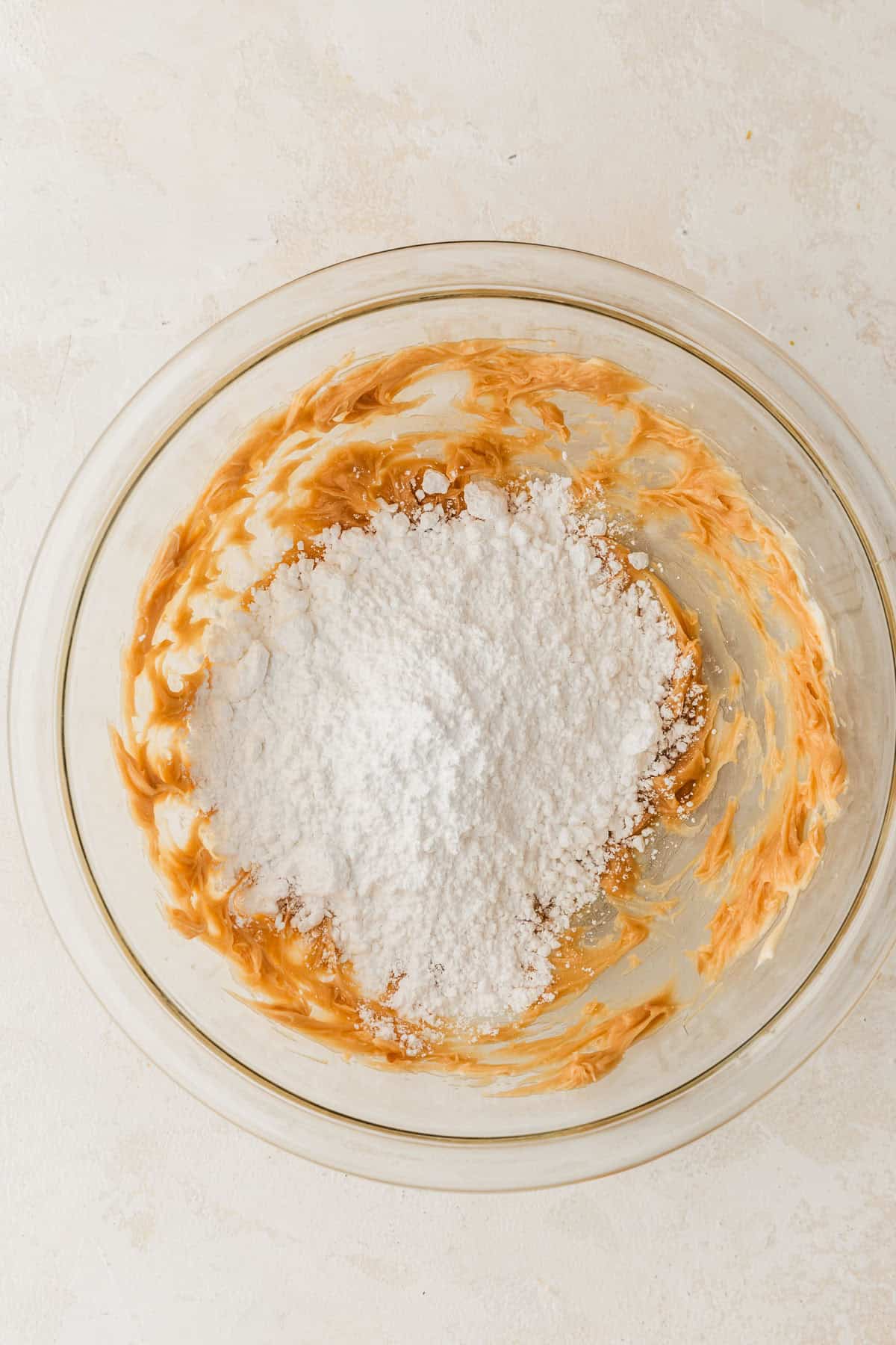 A clear bowl of whipped butter and caramel and powdered sugar.