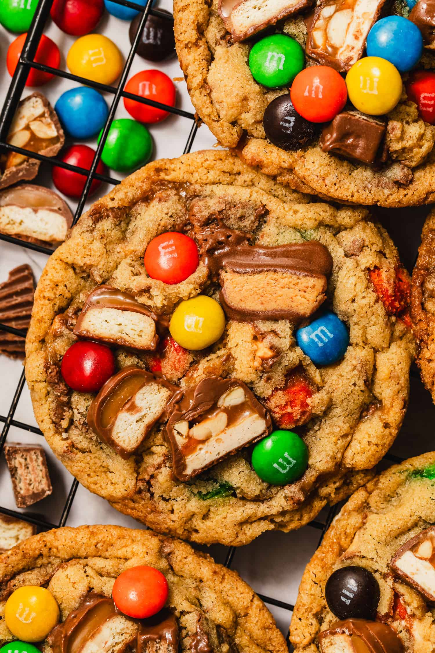 Rows of small batch leftover Halloween candy cookies on a wire rack.