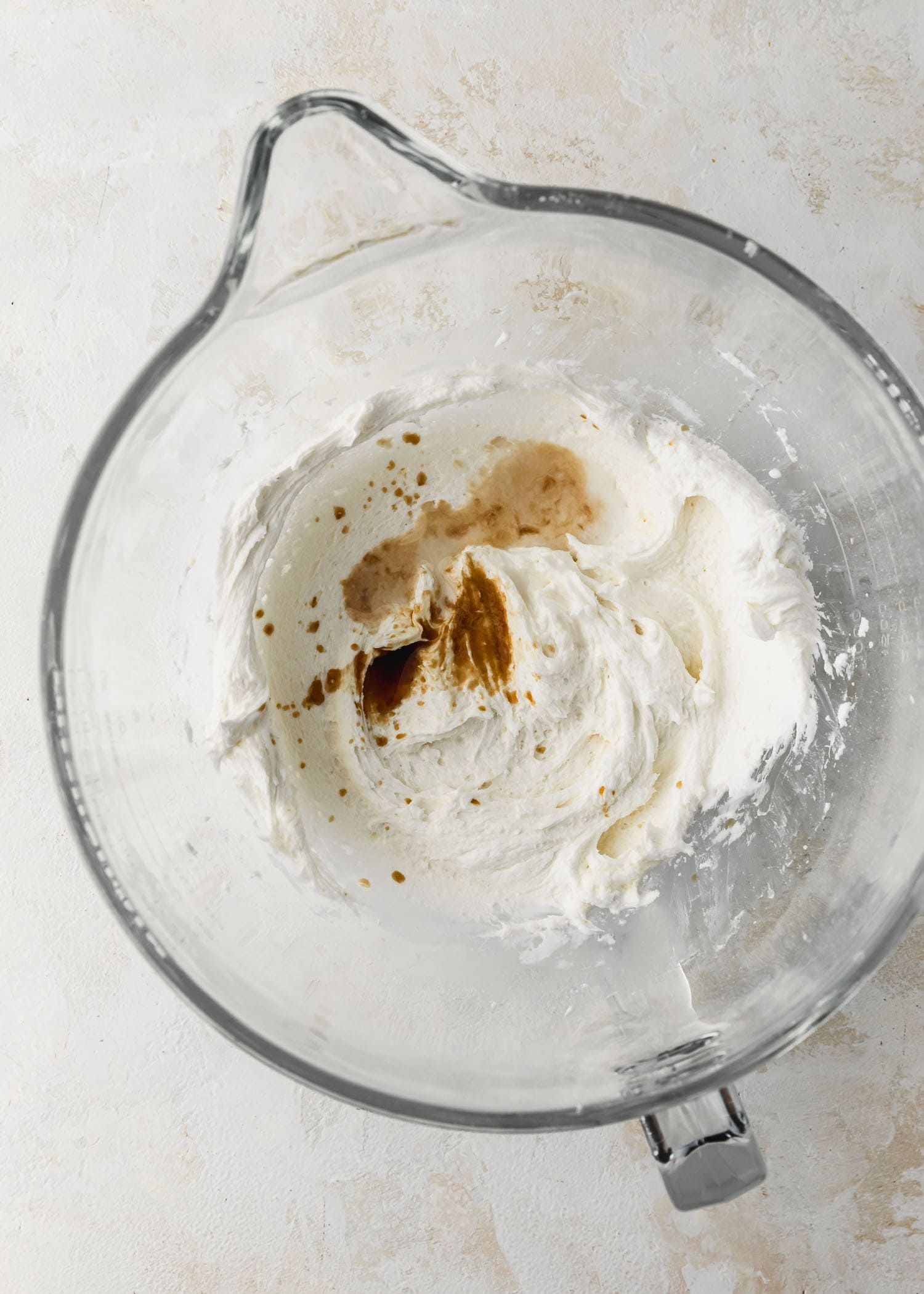 A clear bowl of marshmallow buttercream for small batch ghost cupcakes with vanilla extract and salt.