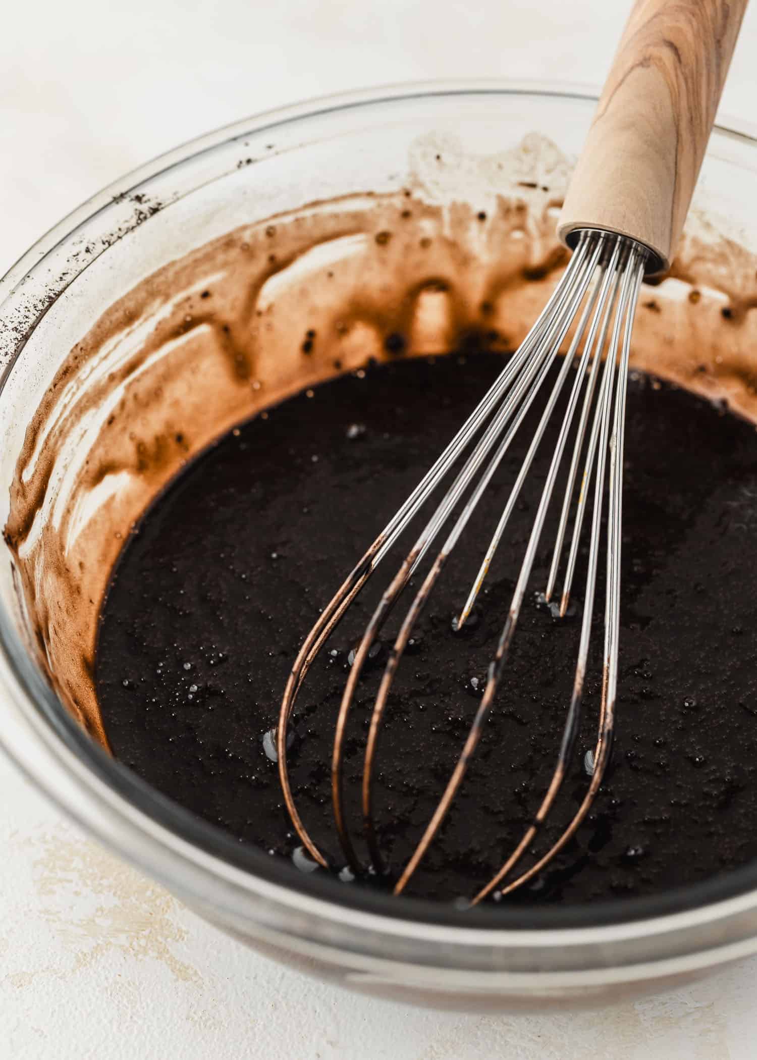 A clear bowl of batter for small batch black velvet ghost cupcakes.