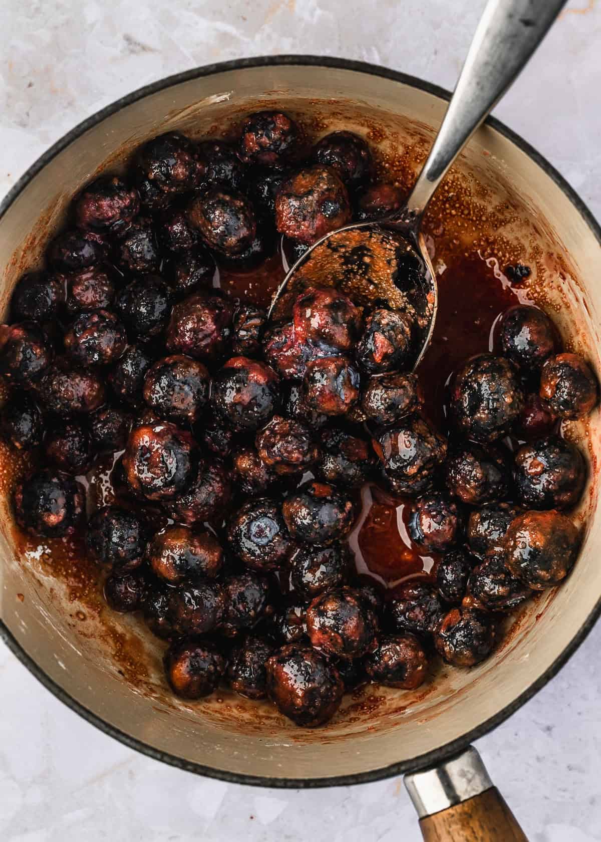 A white pot of blueberries mixed with cornstarch, sugar, and balsamic vinegar.
