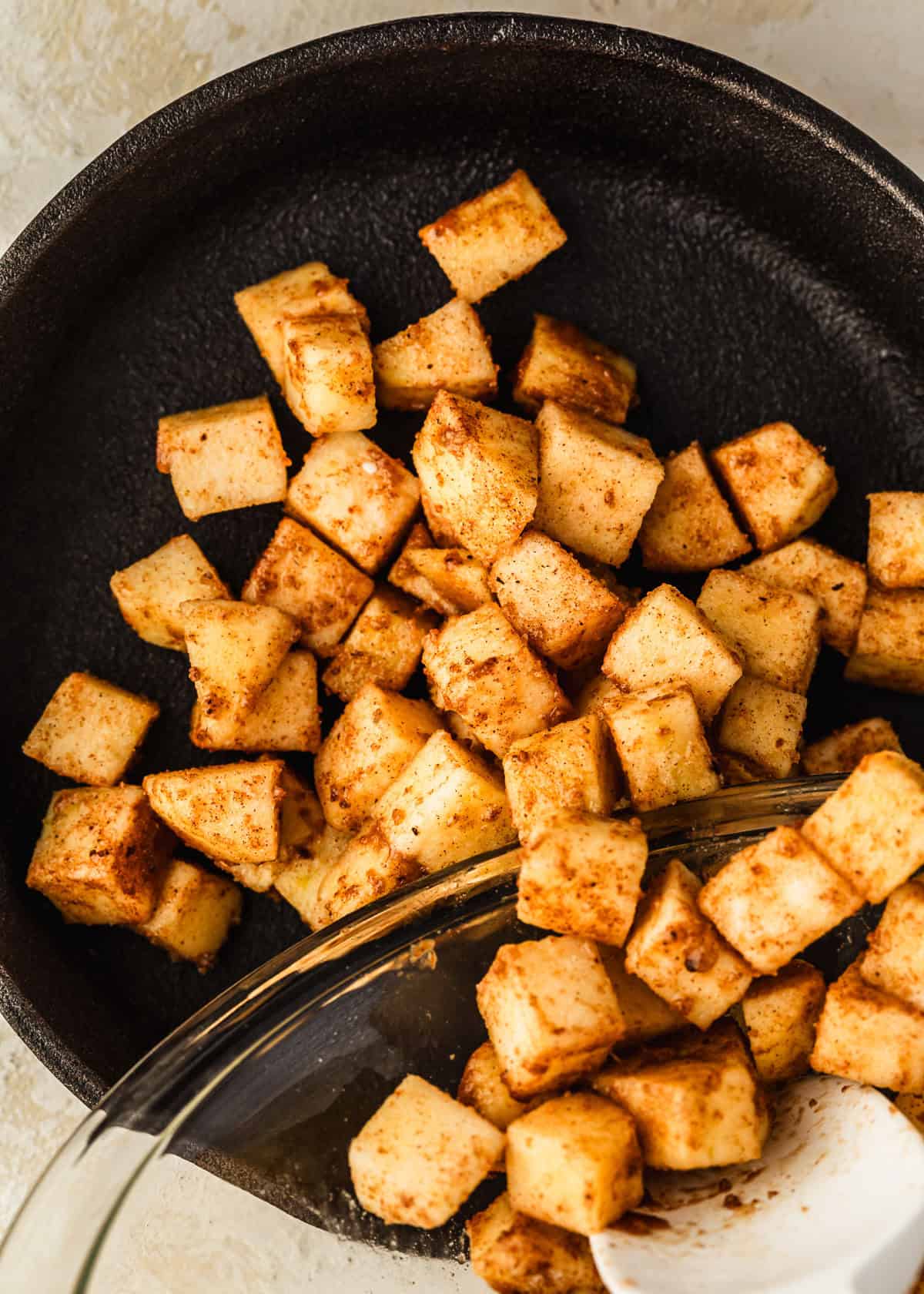 A black skillet of filling for a single-serving apple crisp.